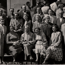 [Grupa ludzi na schodach przed budynkiem]