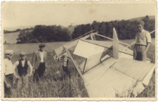 [Czterej mężczyźni stojący przy fragmencie szybowca]