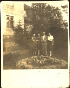 [Trzy kobiety i mężczyzna przed domem]